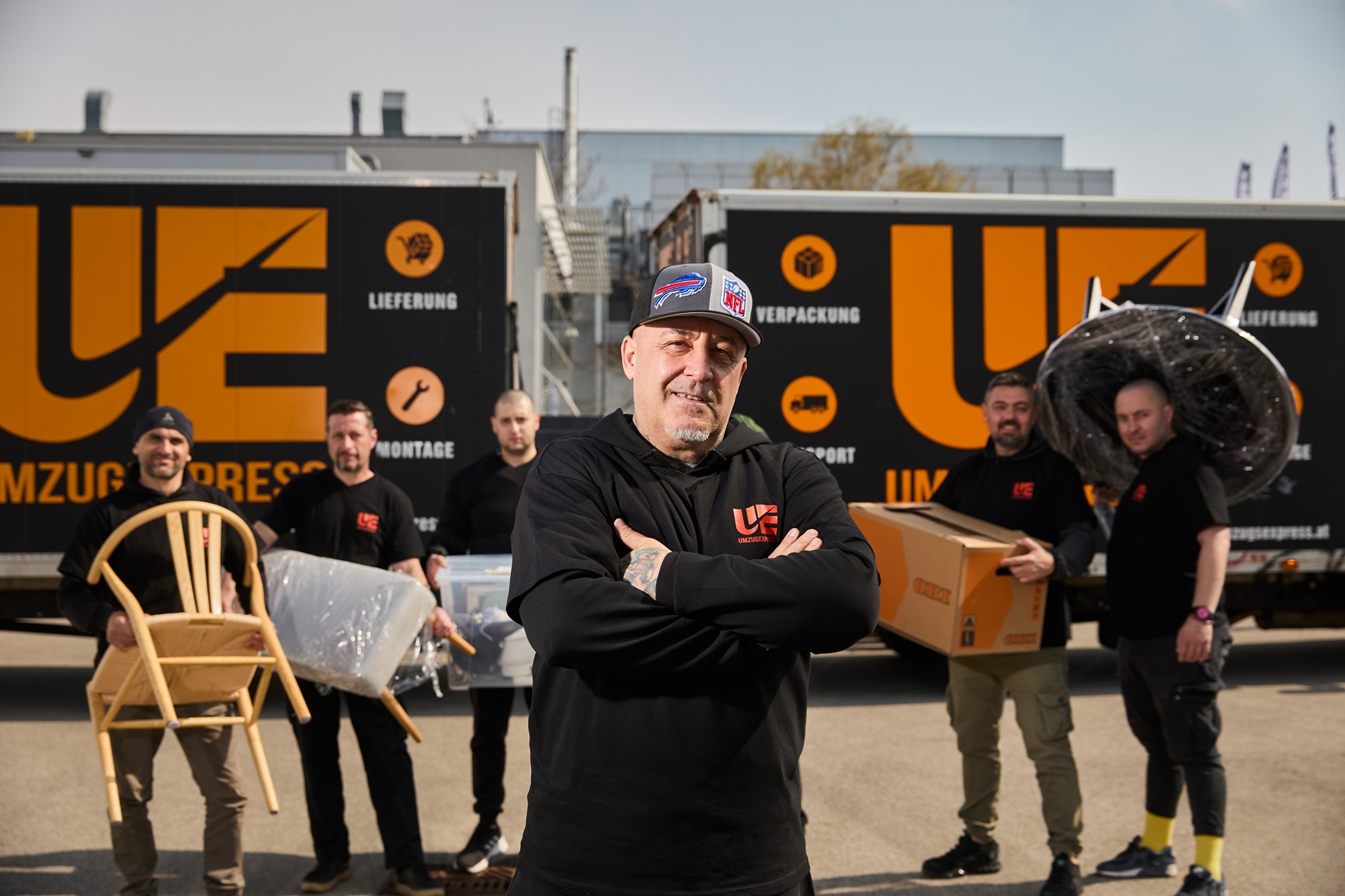Teamleiter von Umzugsexpress steht mit verschränkten Armen vor dem LKW – Symbol für Zuverlässigkeit beim Firmenumzug